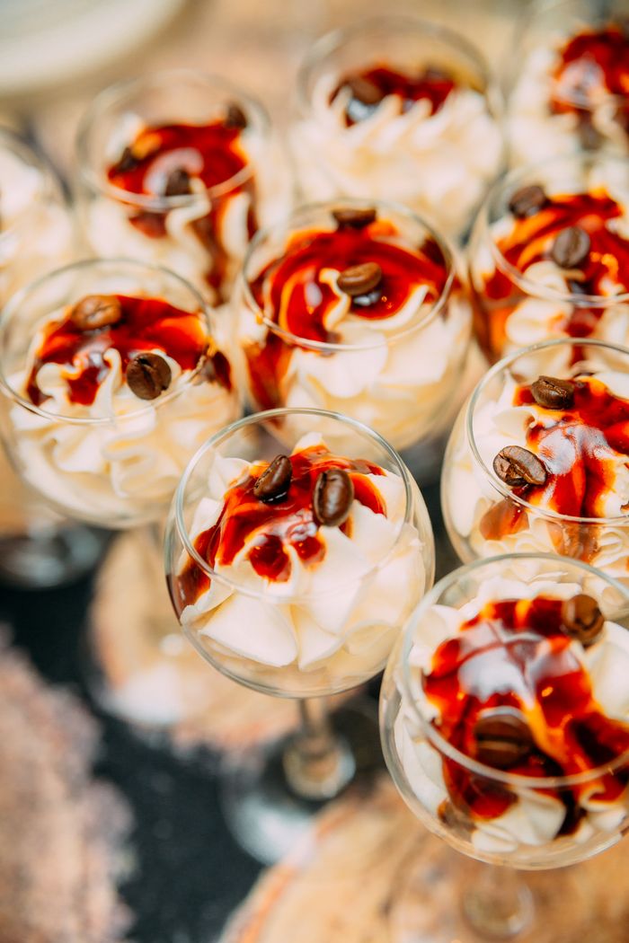 From above of crystal glasses filled with sweet cream dessert and decorated with coffee beans